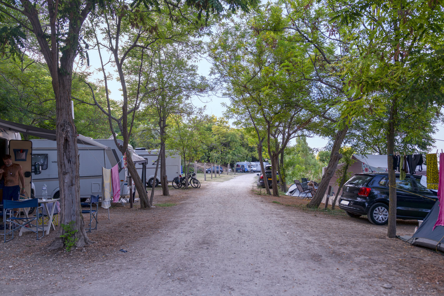 Viale ombreggiato dell'area camper con roulotte e tende
