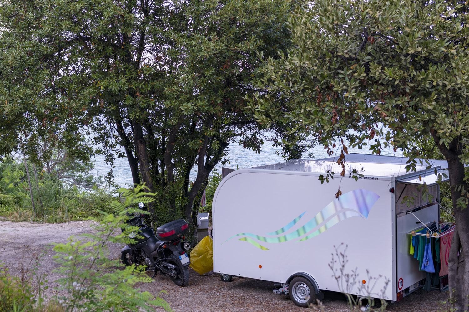 Piazzola camper all'ombra degli alberi con vista sul mare
